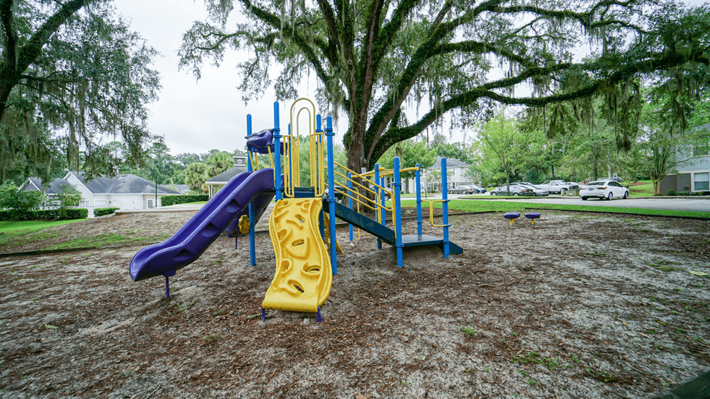 a playground with a yellow slide and a blue slide