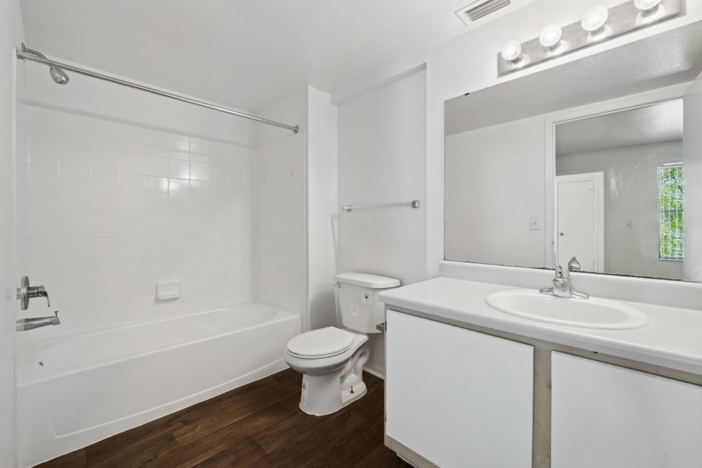 A white bathroom with a toilet, sink, and bathtub.