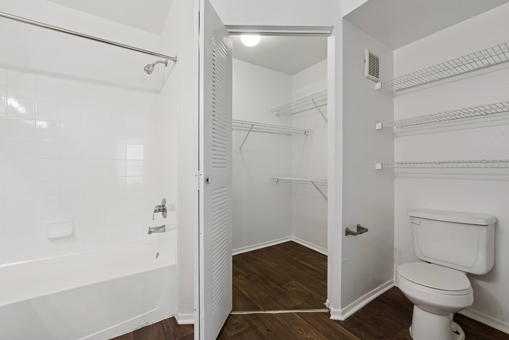 A white bathroom with a toilet and a walk in shower.