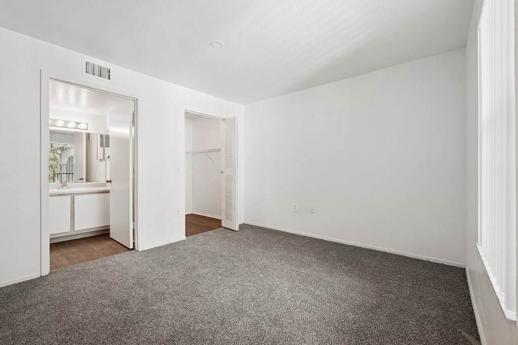 A room with a grey carpet and white walls.