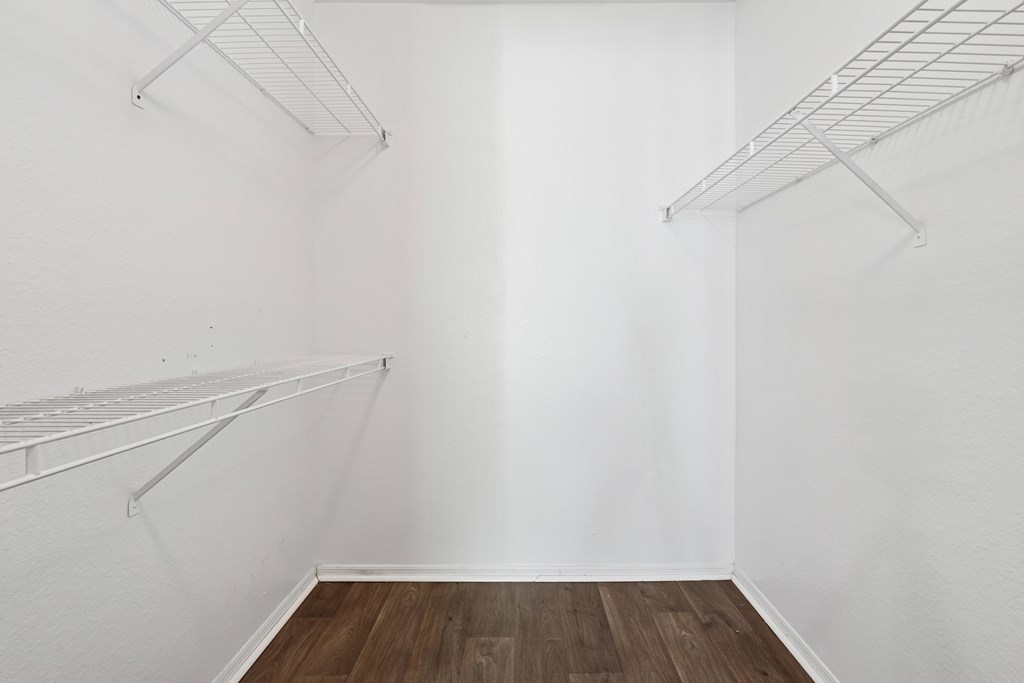 Empty room with white walls and wooden floor.