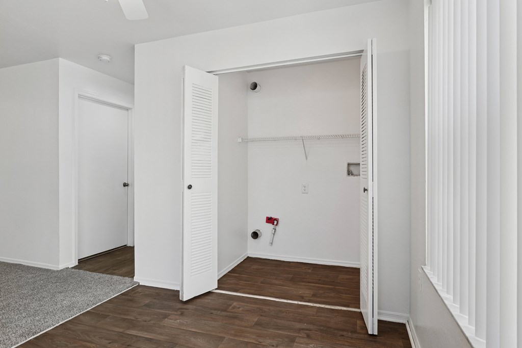 A white room with a door open to another room.
