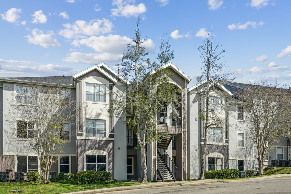 A large apartment complex with a mix of grey and white buildings.