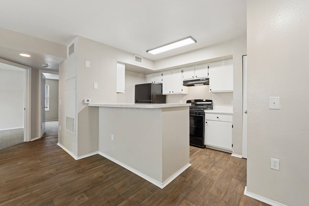 A kitchen with white cabinets and a black oven.