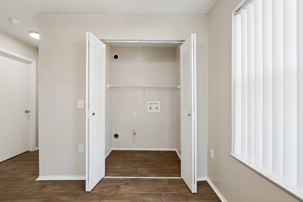 A white room with a closet and a window with blinds.