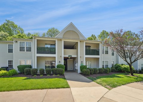 A large apartment complex with a green lawn in front.