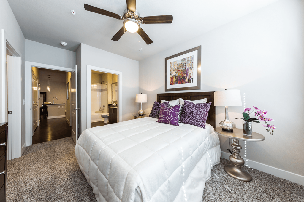 a bedroom with a large bed and a ceiling fan