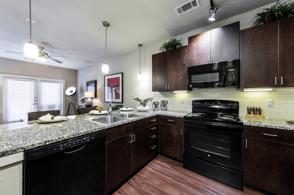 a kitchen with dark wood cabinets and granite countertops