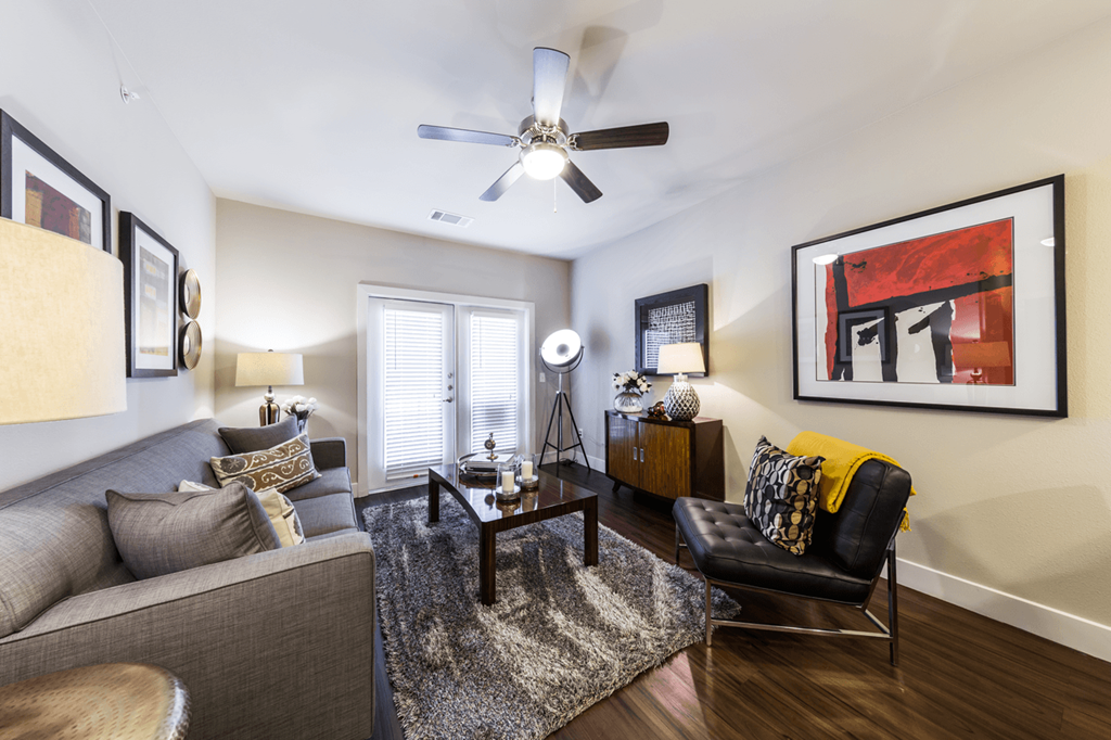 a living room with a ceiling fan and hardwood flooring