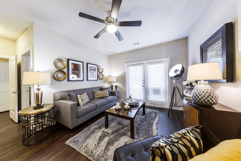 a living room with a ceiling fan and hardwood flooring