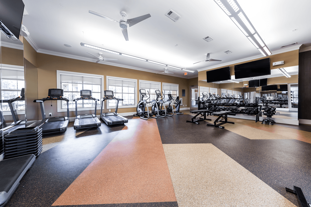 a spacious fitness center with treadmills and other exercise equipment
