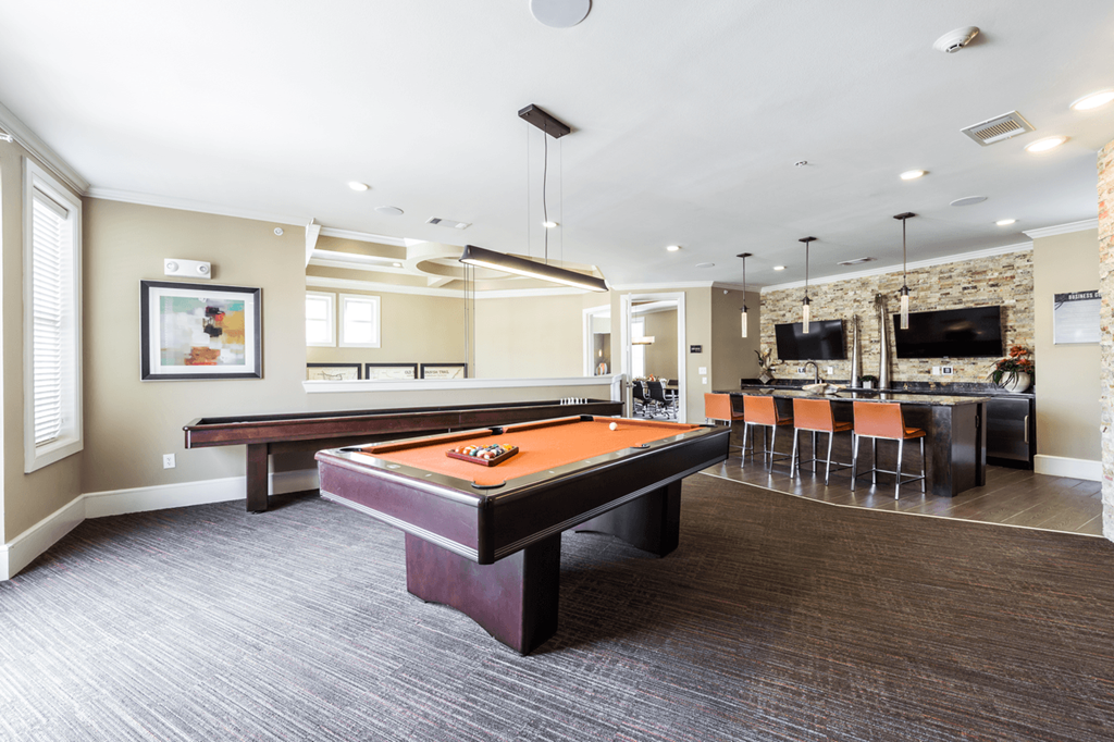 a games room with a pool table and bar