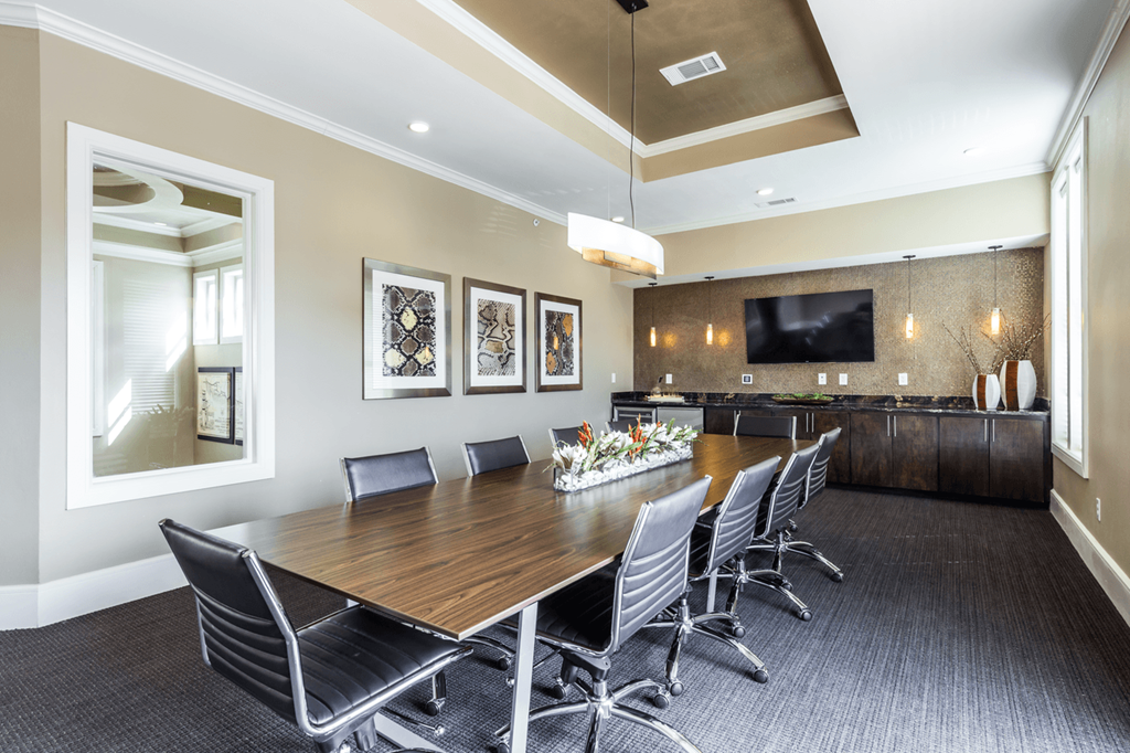 a conference room with a long wooden table and black chairs