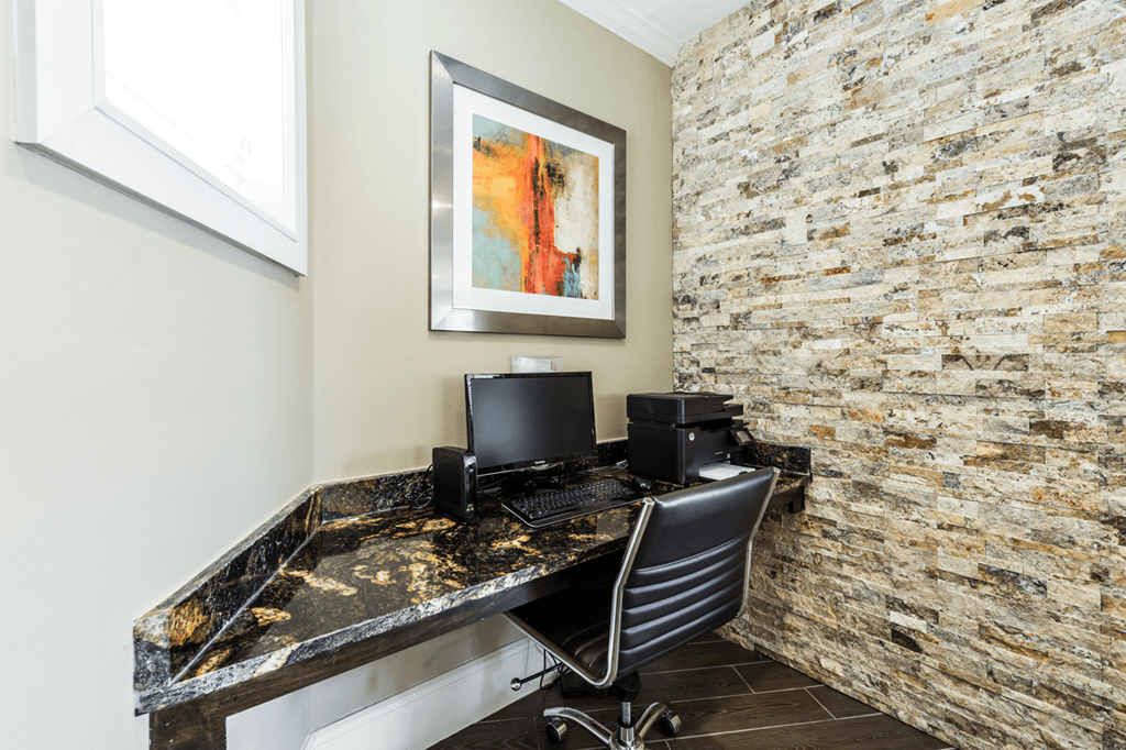 a home office with a brick accent wall