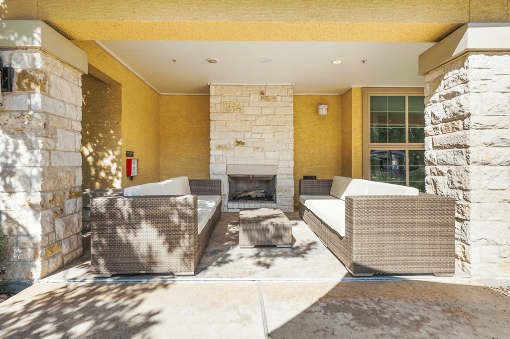 a patio with couches and a fireplace