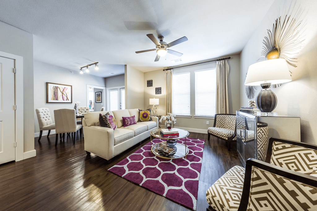 a living room with hardwood flooring and a ceiling fan