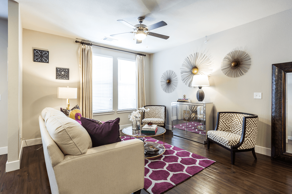 a living room with a ceiling fan and a large window