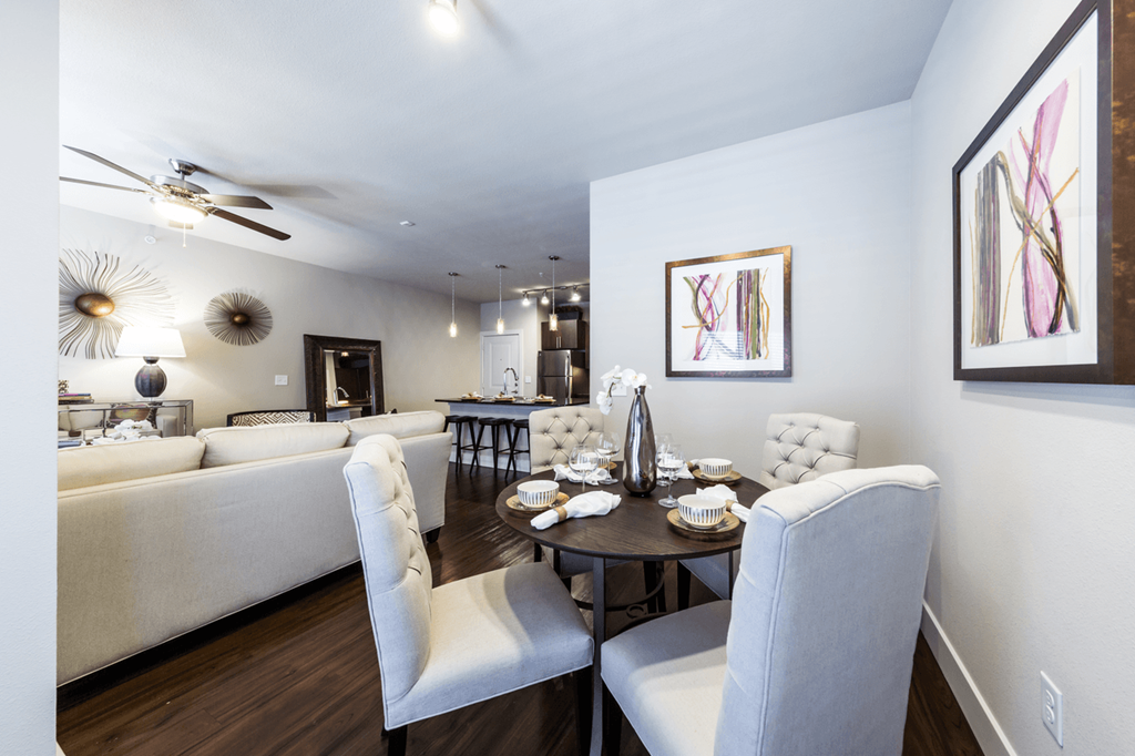 a living room and dining room with white couches and chairs