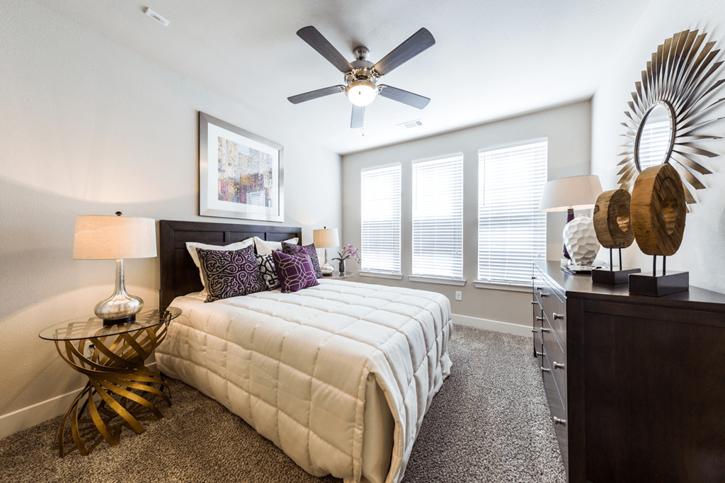 a bedroom with a large bed and a ceiling fan