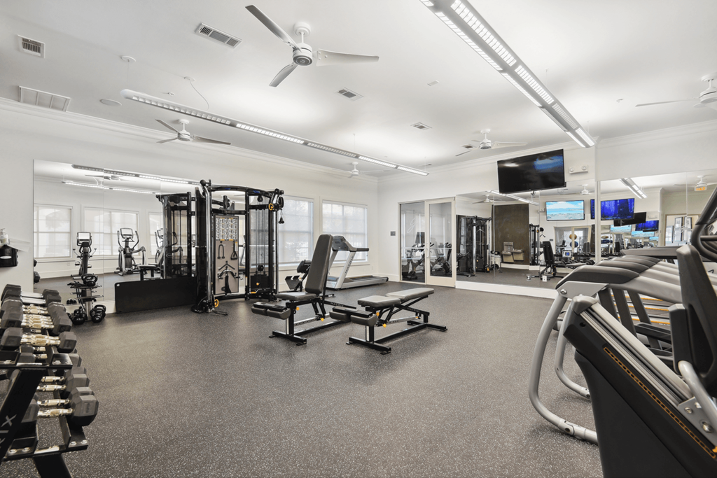a gym with cardio machines and weights in it