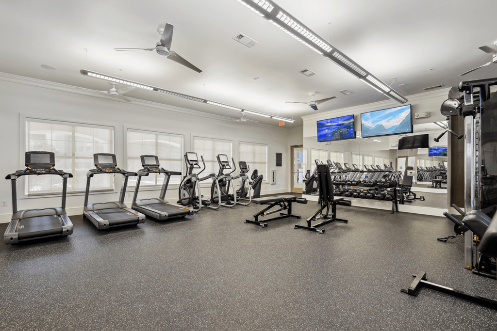 a fitness room with treadmills and other exercise equipment