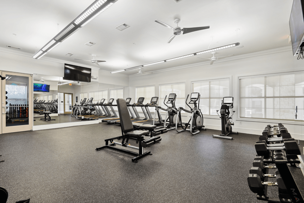 the gym with cardio equipment and weights at the belgard apartments