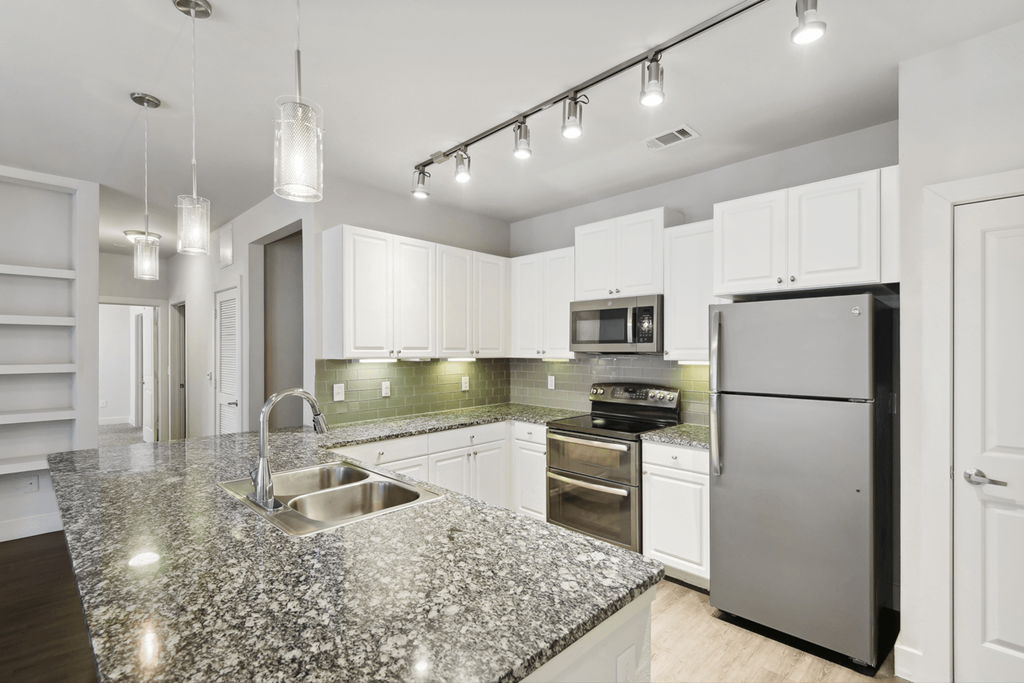 a kitchen with granite counter tops and stainless steel appliances