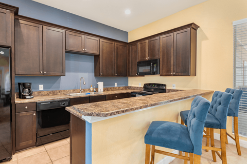 A kitchen with brown cabinets and a granite countertop.
