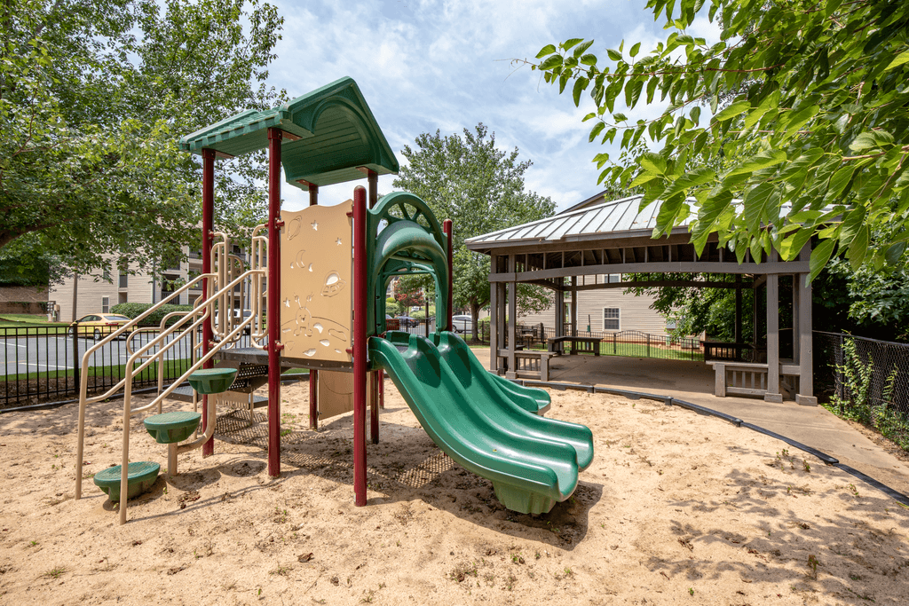 a playground with a slide and swings at a park