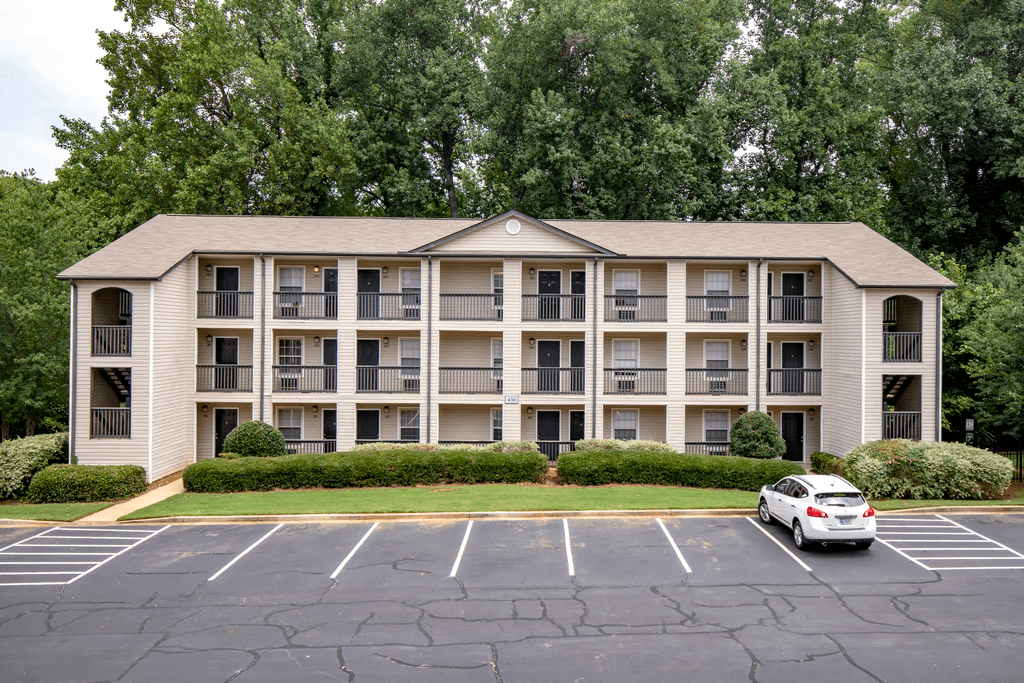 an apartment building with a car parked in a parking lot