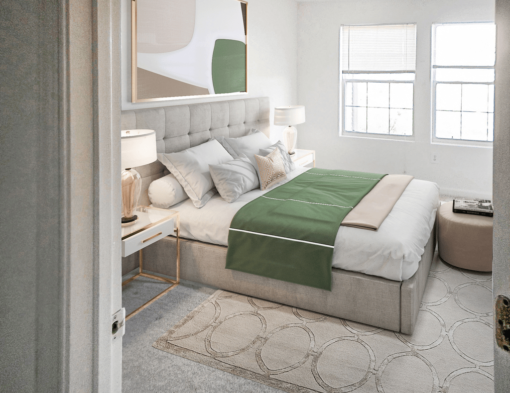 Virtually staged bedroom with white walls and ceilings. The room has a bed, two end tables with lamps, an accent rug and two windows on the opposite wall.