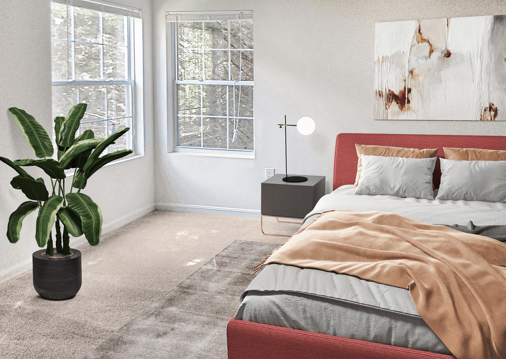 Bedroom with two windows, white walls and beige carpet virtually staged with a bed, wall art, side table with lamp and a standing plant