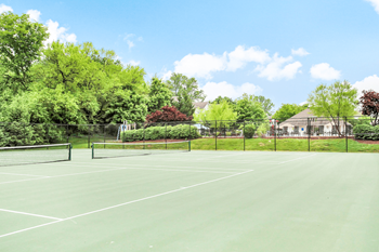 Two tennis courts facing swimming pool and playground surrounded by native landscaping