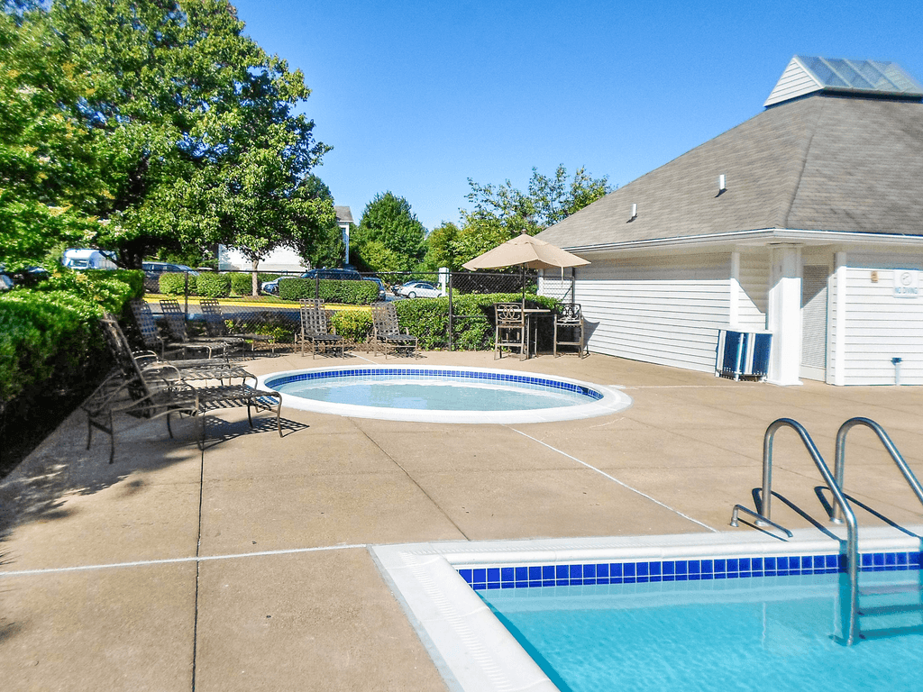 Outdoors kids pool with tanning chairs on the sun deck surrounded by native landscaping