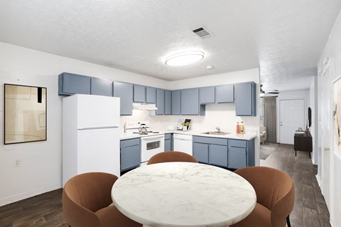 A kitchen with a white refrigerator and blue cabinets.