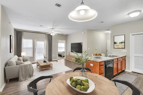 A modern kitchen with a wooden table and chairs in the foreground.