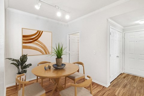 A dining room with a wooden table and chairs.
