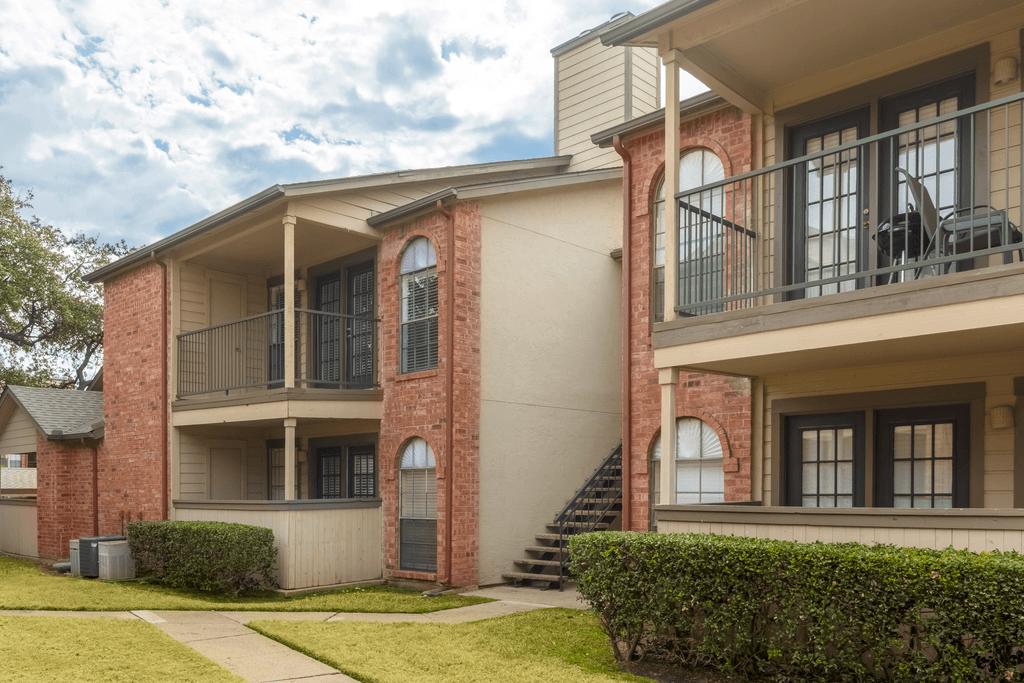 Building exterior with balconies or patios, sidewalk, exterior stairs and native landscape