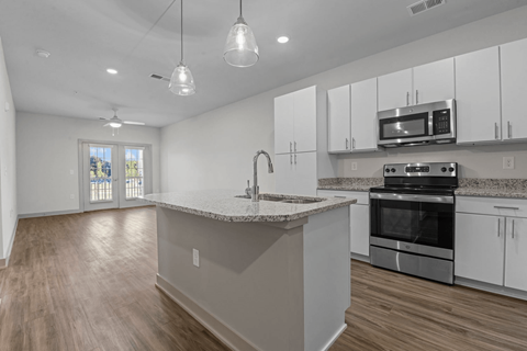A kitchen with white cabinets and a granite countertop.
