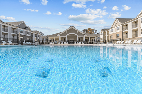 A large swimming pool in front of a resort.