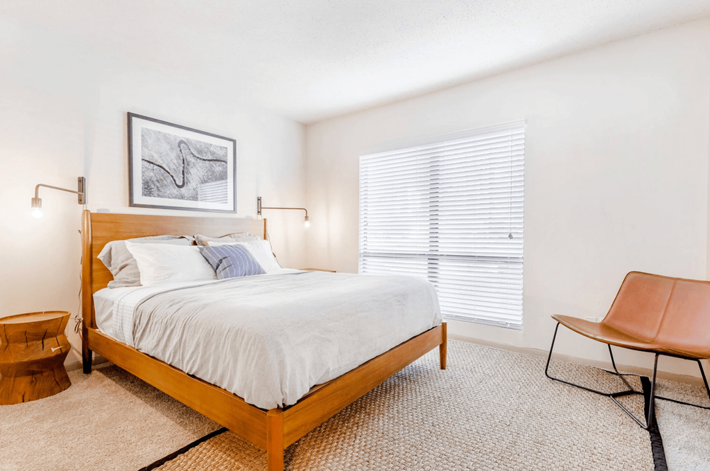 A bedroom with a bed, chair, and picture on the wall at Madison Southpark Apartment Homes, Charlotte, NC