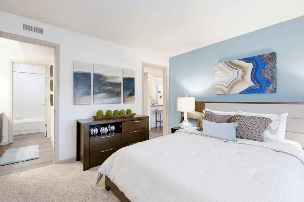 A bedroom with a large bed and a painting on the wall at Madison Southpark Apartment Homes, Charlotte, North Carolina