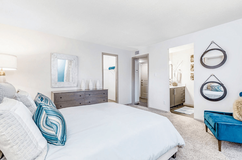 A bedroom with a large bed and a blue couch.
