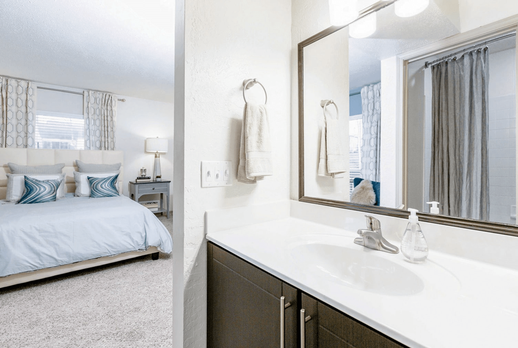 A white bathroom with a bed and a mirror at Madison Southpark Apartment Homes, North Carolina
