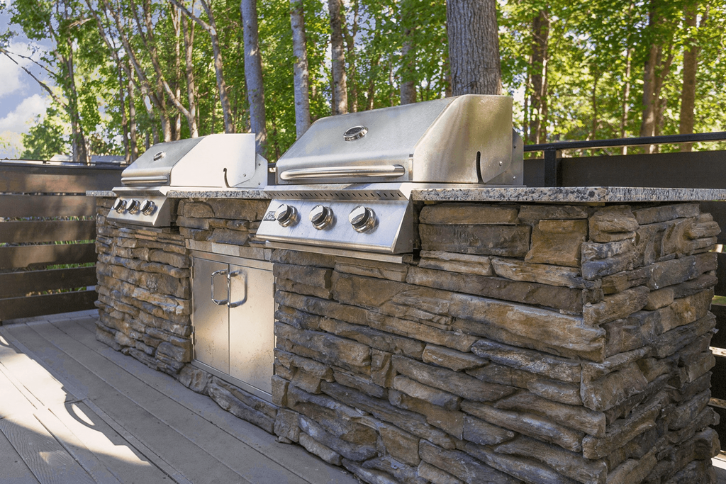 A stone wall with a grill on top at Madison Southpark Apartment Homes, Charlotte, 28226