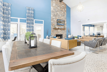 A dining room with a wooden table and white chairs at Madison Southpark Apartment Homes, Charlotte, North Carolina