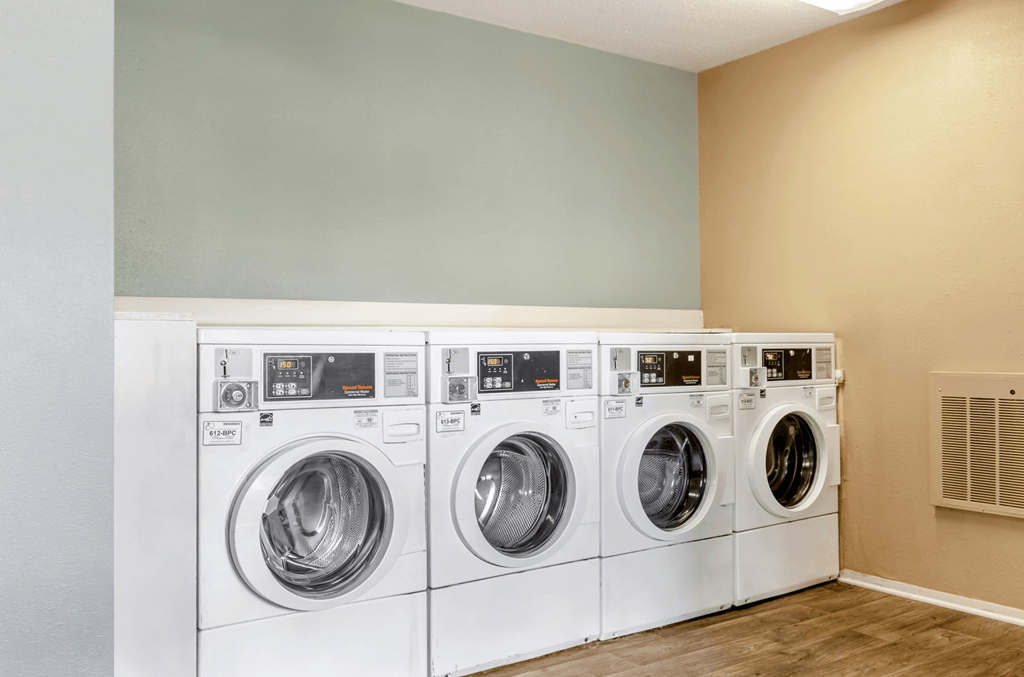 A row of white front load washing machines in a laundry room at Madison Southpark Apartment Homes, Charlotte
