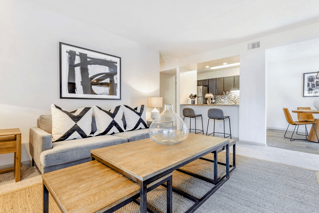 A modern living room with a grey couch and a wooden coffee table at Madison Southpark Apartment Homes, Charlotte, NC, 28226