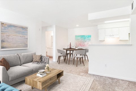 A living room with a grey couch, a coffee table, and a painting on the wall.