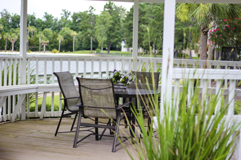 gazebo with a table and chairs with a lake in the background